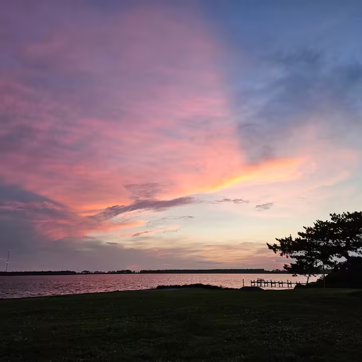 A pink and golden evening sky over Nelson’s Bay in Sea Level